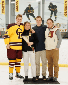 Tyler stands with his family on an ice rink